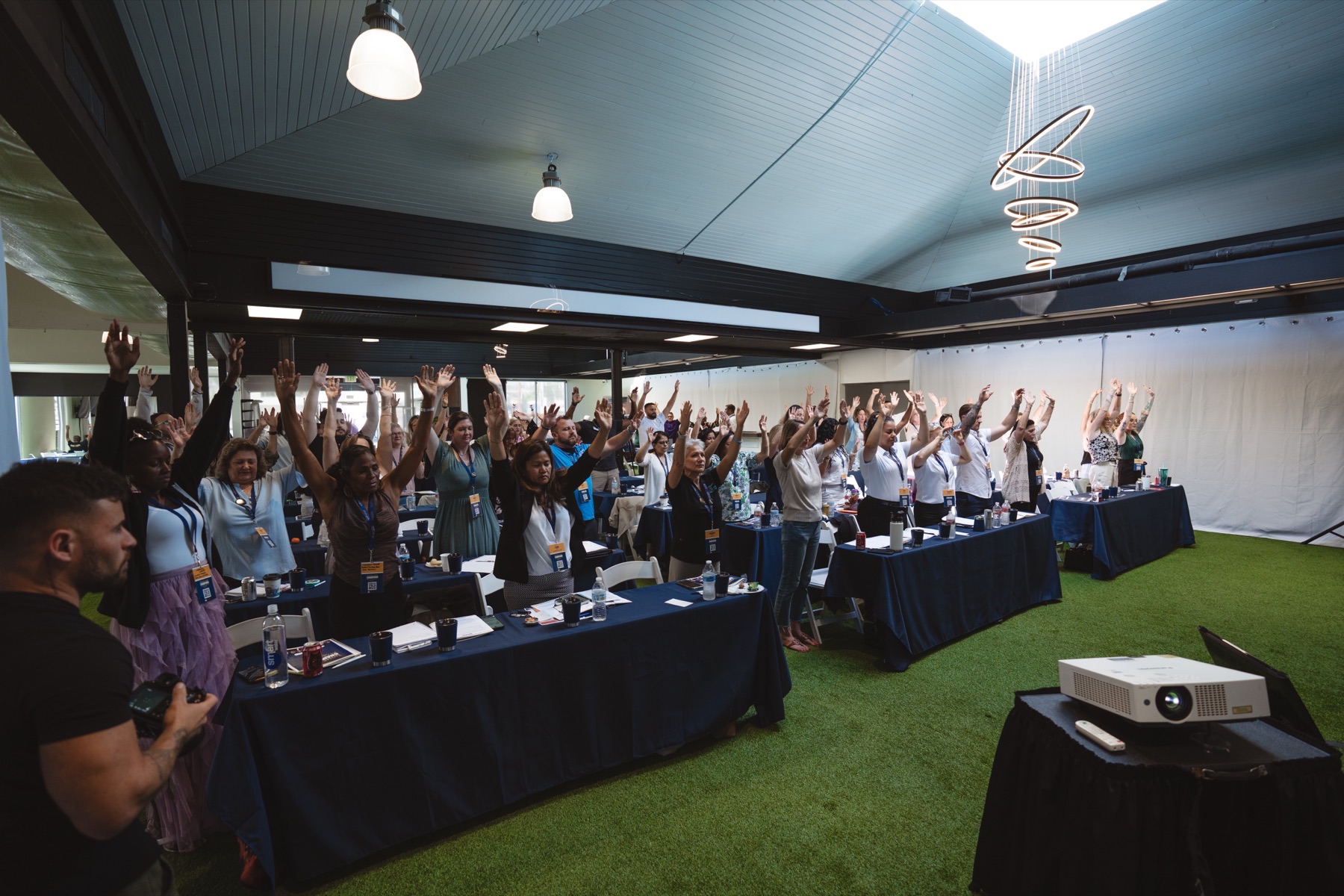 A full room of home care owners on their feet with hands raised at the Home Care Champions Experience